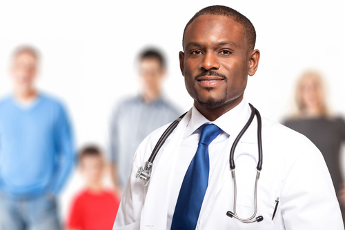 Male doctor standing in front of four people of various ages