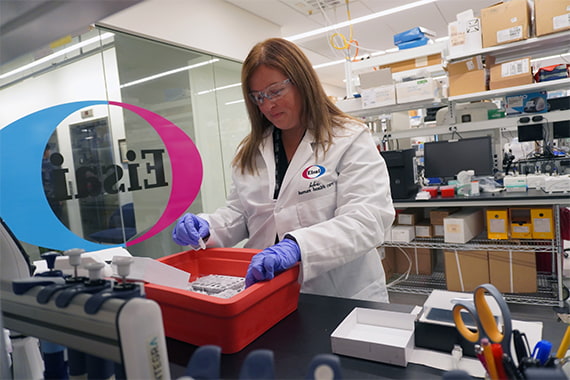 Two Asian scientists in a lab looking at a computer monitor