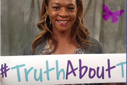 A woman holding a sign that says #truthabouttc 