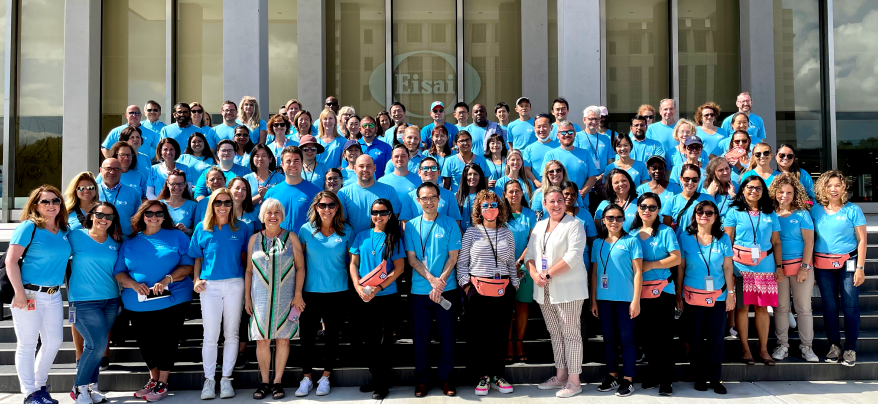 A group of Eisai employees standing in rows on the steps in front of an Eisai building