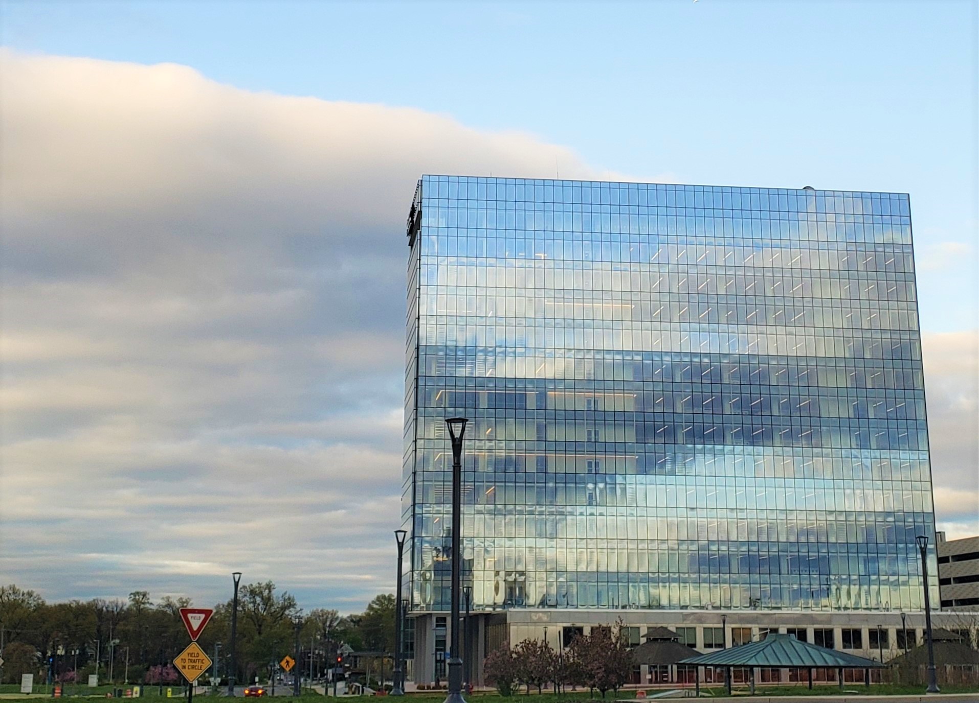 A street-view of a corporate Eisai building with glass exterior and clouds in the skyline