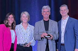 A woman in a white lab coat browsing through documents in the drawer of a file cabinet 