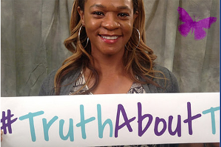 A woman holding a sign that says #truthabouttc